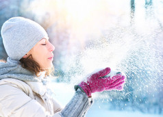 美丽的冬天女人吹雪户外