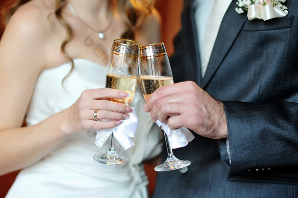 特写手中新娘和新郎戴着眼镜的香槟