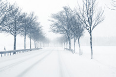 冬季驾驶-警告标志的乡间路上的降雪