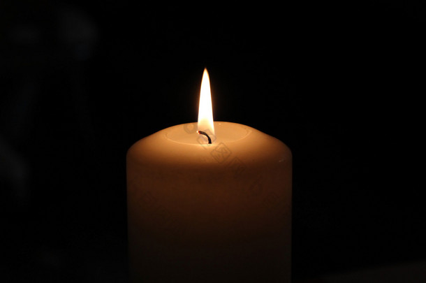 一个燃烧的蜡烛在黑暗中