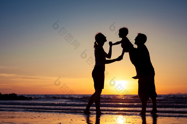 幸福的家庭的剪影在<strong>一元</strong>在沙滩上玩的人