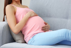 怀孕的女人在沙发上休息