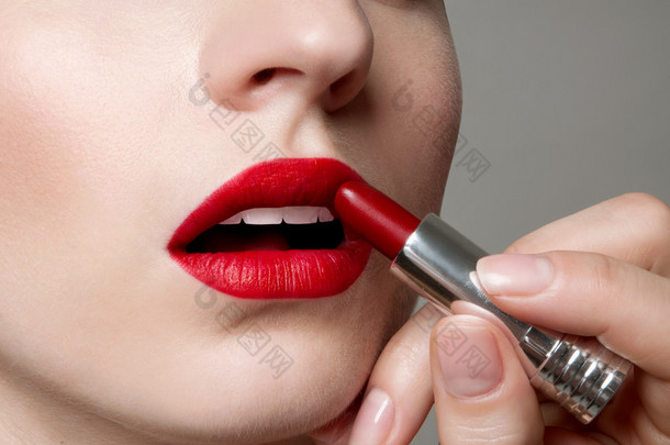 仕女画在完美的嘴唇上应用红色唇膏弥补.