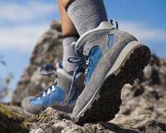 徒步旅行靴和腿攀爬岩石径的特写