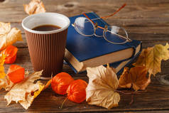 秋天的场景。咖啡杯子和书籍