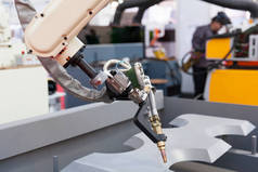 工业焊接机器人手臂中焦，在背景中的模糊焊机
