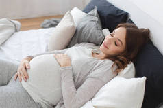 怀孕微笑女性躺在床上