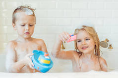 孩子们玩在带有泡沫的浴缸