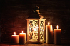 老式灯笼与燃烧的蜡烛和松树锥木桌.
