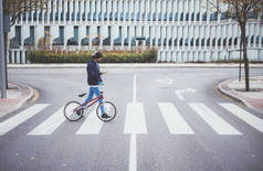 男性骑自行车的男子在街上与电话