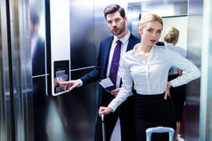 酒店电梯的商人和女商人看着摄像头