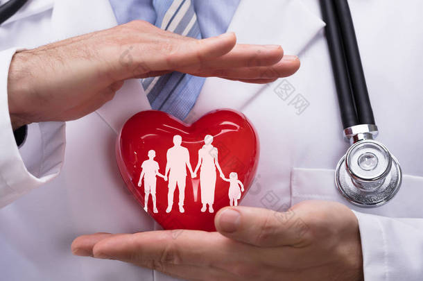 <strong>亲密</strong>的医生的手保护家庭在红色心脏