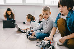 重点儿童编程机器人与膝上型计算机在地板上, 茎教育概念
