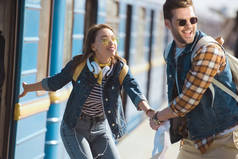 时尚女性旅行者叫男朋友在户外地铁站上火车