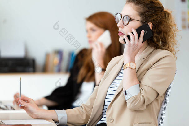 在办公室里用她的手机拍的漂亮年轻的商业女性.