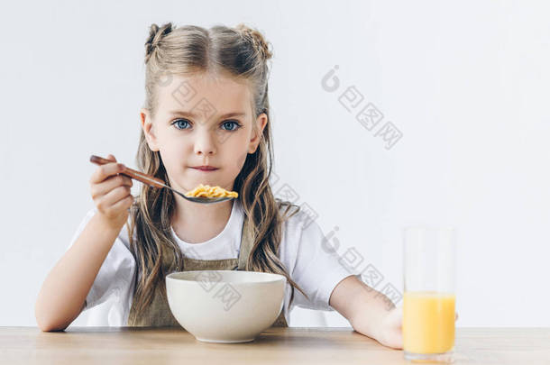 小女生吃健康的早餐隔离在白色和看相机