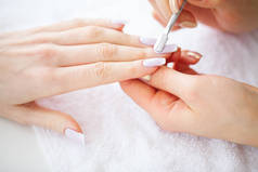 水疗美容。水疗沙龙的法式修指甲。妇女手在指甲沙龙接受指甲手术。修指甲程序.
