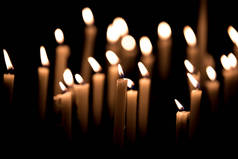 许多燃烧的蜡烛-蜡烛的光在教堂的黑色背景
