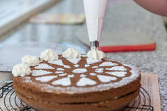 糕点厨师装饰巧克力蛋糕与糖模式和奶油-特写