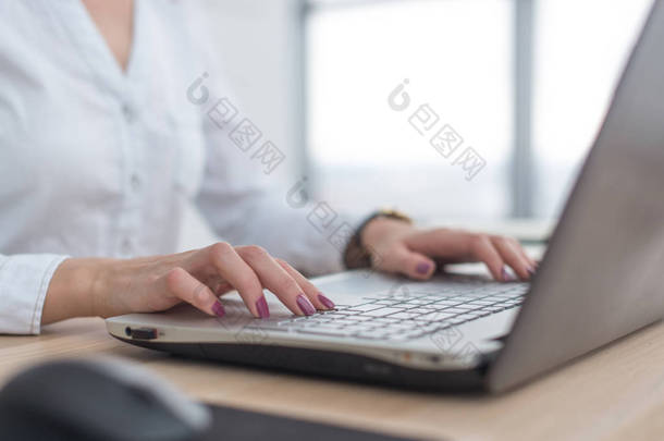 使用笔记本电脑女人写一篇博客。<strong>女性</strong>的双手在键盘上.