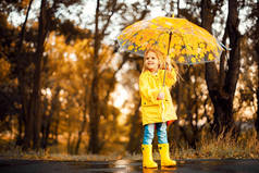 愉快的孩子女孩用雨伞和橡胶靴子秋天步行