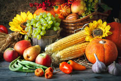 感恩节快乐的背景, 木桌上点缀着南瓜、玉米、水果和秋叶。丰收节。选择性对焦。水平.