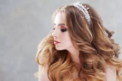 迷人的年轻新娘与豪华发型。穿着婚纱的漂亮女人头发风格与蓬松的卷发.
