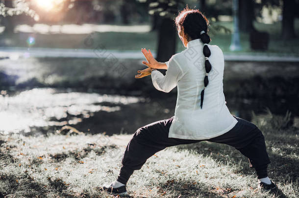 在公园里练习<strong>太极拳</strong>的妇女