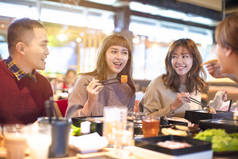 快乐的亚洲年轻人群在餐厅吃饭