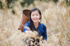 妇女亚洲农夫在草田自然/美丽的年轻亚洲妇女的画像幸福微笑与篮子为收获农业在农村村庄乡村-生活年轻女孩礼服部落