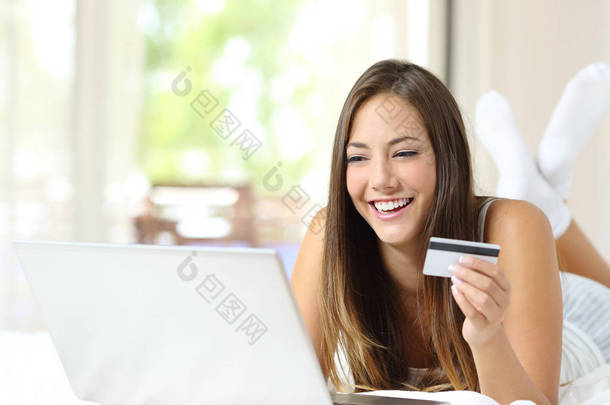 快乐的酒店客人在网上用<strong>信用卡</strong>和笔记本电脑付帐