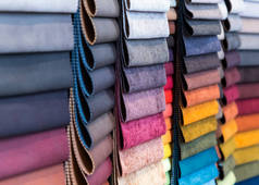 工厂商店或商店中的织物和纺织品样品。市场上有不同的颜色和图案。工业面料.