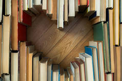 爱情的心形概念来自木制地板背景的旧书。古色古香风格的爱情构图，开卷心形
