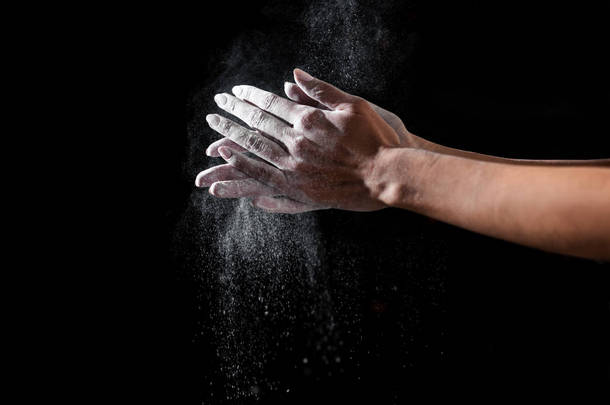 特写部分的运动女子应用滑石粉的手隔离在黑色