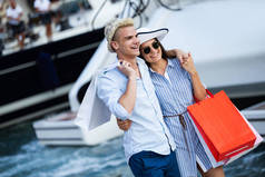 一对夫妇在城市里带购物袋的画像。人、销售、爱情和幸福概念.