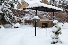 后院天井. 有烧烤区的风景, 白雪的雪堆, 乡村花园里的松树。乡村生活理念.