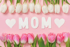 白色和粉红色的郁金香, 纸字妈妈和纸心粉红色的背景