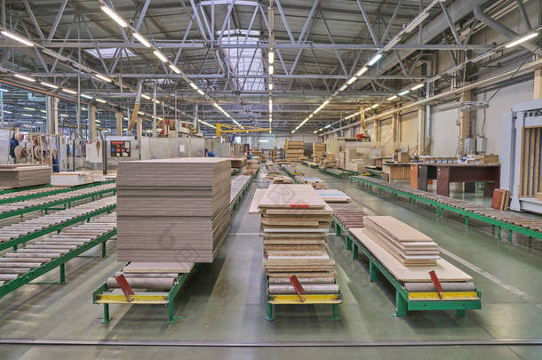 在某木工企业中铺设家具<strong>加工</strong>和生产用刨花板。一家家具厂的生产线。木材<strong>加工</strong>用铣床和锯床.