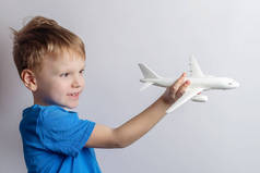 一个六岁的男孩在玩一个客机的玩具模型。旅行梦想概念