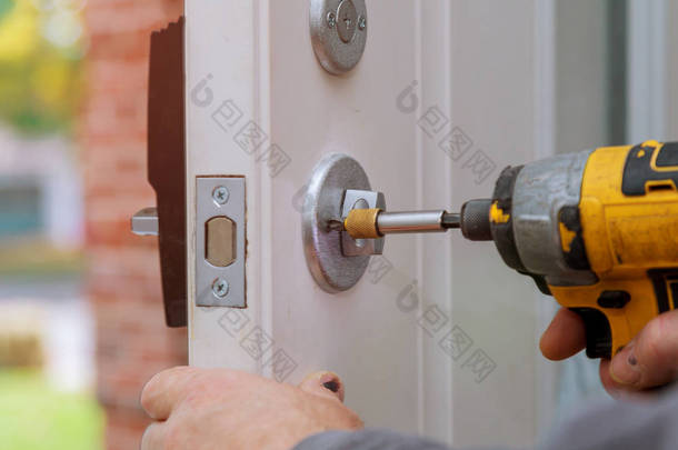 杂工修理工人手中的门锁安装新的门锁