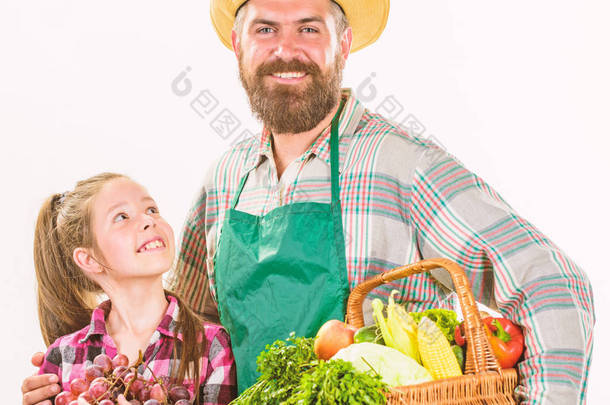 有孩子的有胡子的乡下农夫。农民家庭自主收割。父亲农夫或园丁与女儿举行篮子收获蔬菜。园艺和收割。家庭农场有机蔬菜