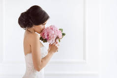 漂亮的新娘和她的花。婚纱、化妆、豪华服装和花束