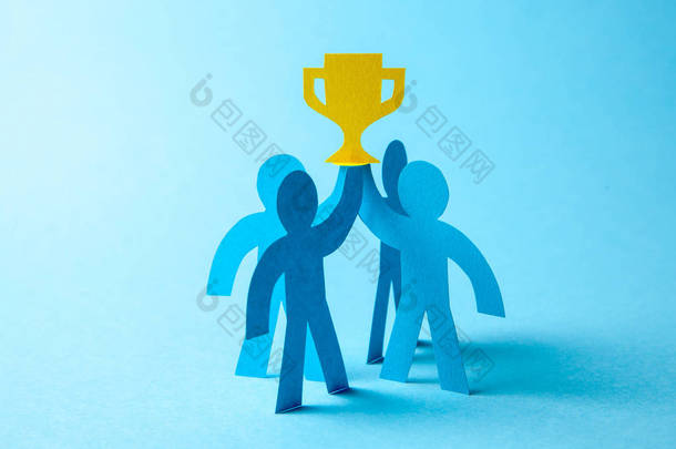 成功的商业团队冠军手里拿着金杯。团队建设。领导者和工人实现目标.