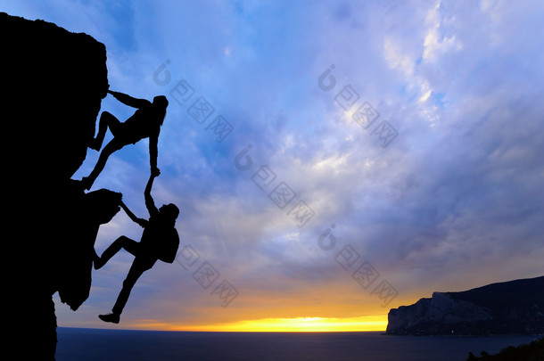 两个男人旅行联合工作团队在登山团队，美丽的日落景观互相帮助