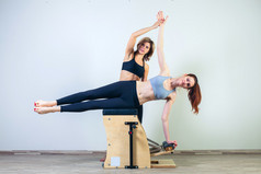 组合旺达与教练健身瑜伽健身锻炼普拉提椅子上的女人
