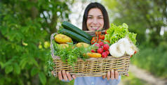 美丽的少女，拿着一筐蔬菜，在大自然的背景中。概念︰ 生物、 生物产品、 生物生态种植蔬菜、 自然清新产品、 健康的素食主义者.