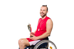 运动员在轮椅上抱着奖杯