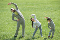 父亲与女儿和儿子做体育锻炼在草