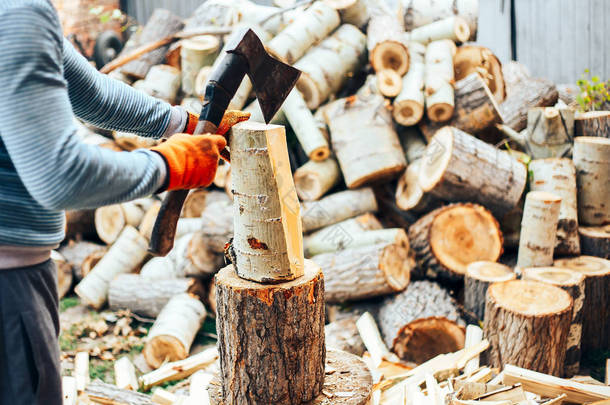 用锯木屑在木头上飞行的两片木头的细节。人类正在用老旧的斧头砍柴.冻结的时刻.