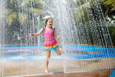 孩子们在水上公园玩耍。热带游乐园水上游乐场的孩子们。小女孩在游泳池。在亚洲的暑假,孩子们在玩滑水游戏.小孩子穿的泳衣.